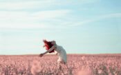 woman in yellow dress standing on pink petaled flower field