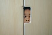 playful black little girl hiding in closet