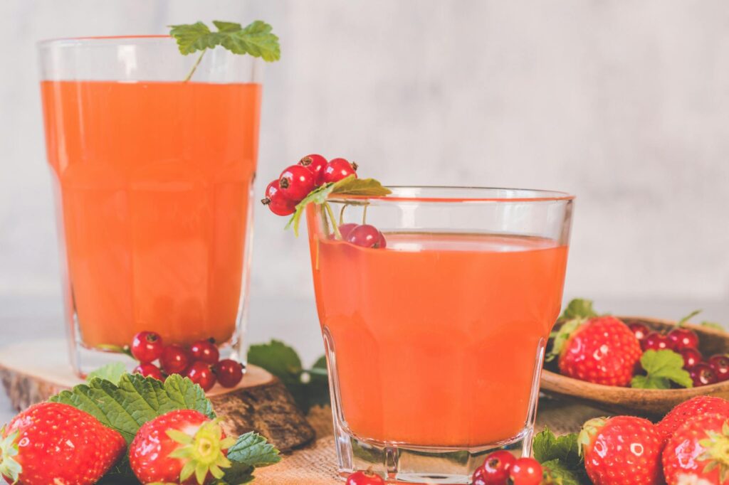 two clear drinking glasses with strawberry juice