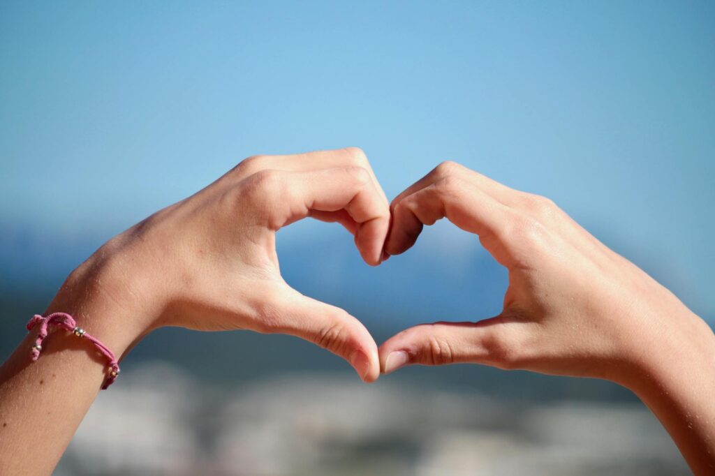 person doing heart hand sign