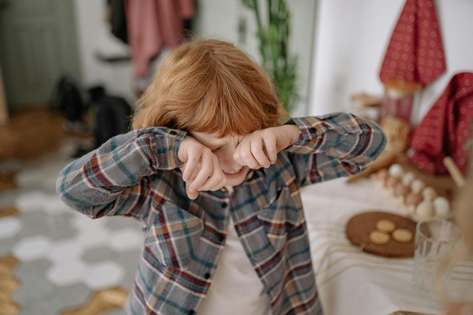 a boy crying while covering eyes