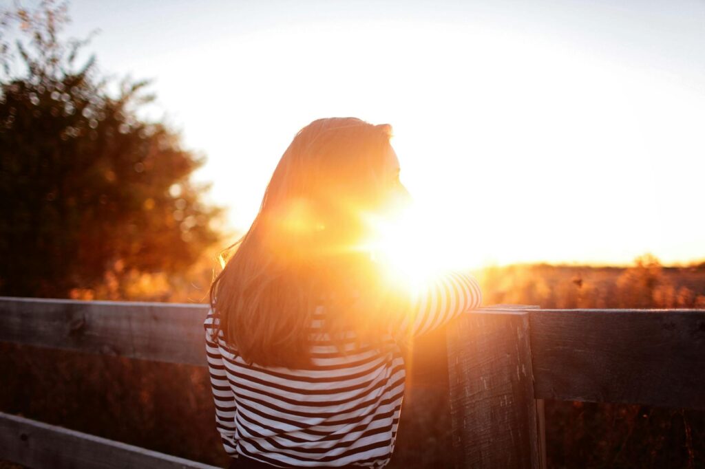 rear view of woman standing in balcony during sunset