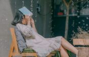 woman sitting on chair while holding book