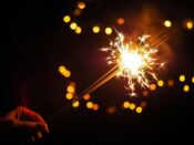 person holding lighted firecracker